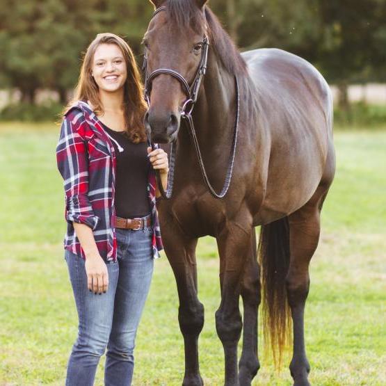 A equine studies student stands with a horse